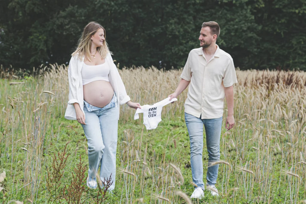 babybauch-schwangerschaft-shooting-im-feld-mit-blumen-outdoor-natuerliche-fotografie-paarshooting